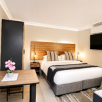 Fully furnished studio apartment with king-size bed and work area at 1 on Daphny